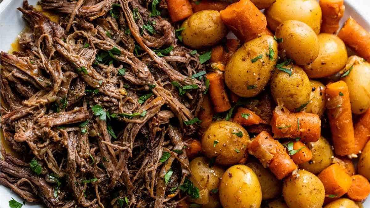 A plate of roast beef with potatoes and carrots.