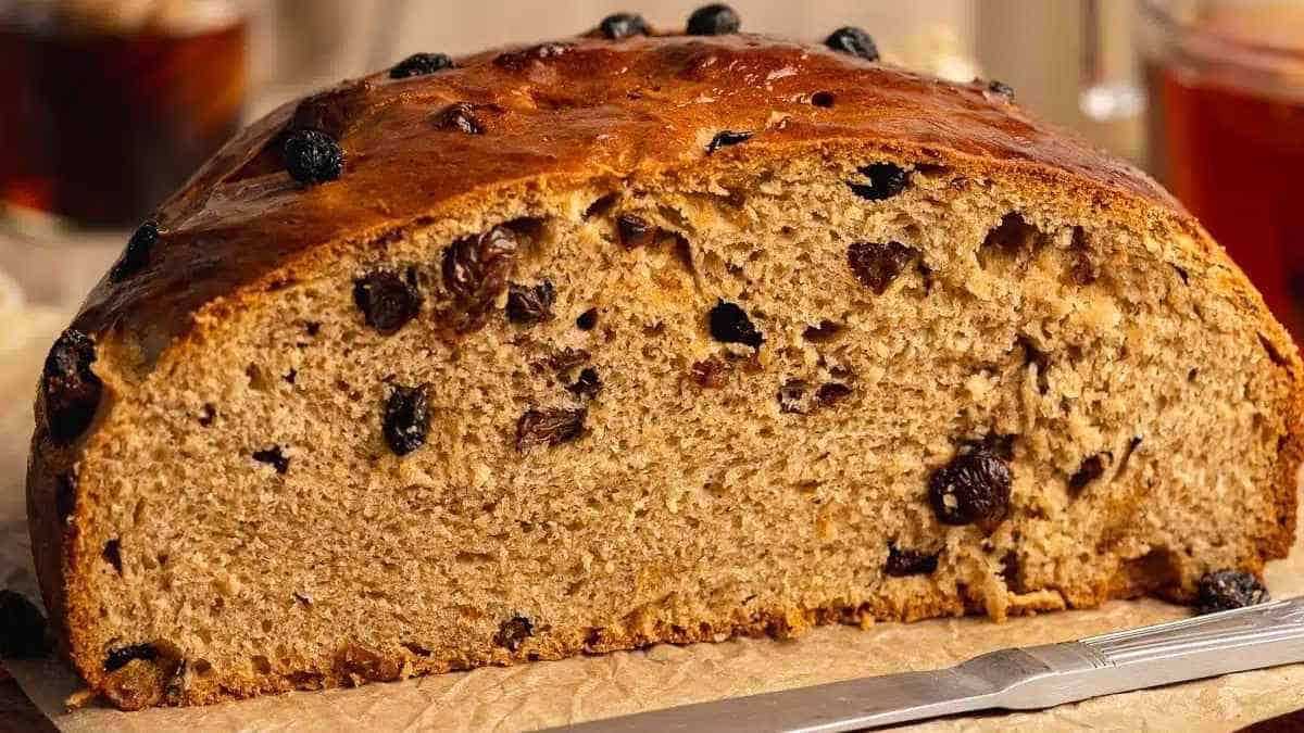 A loaf of bread with raisins on top.
