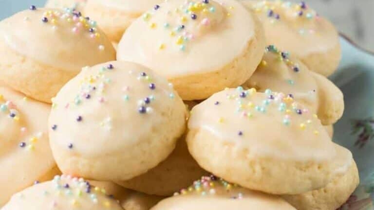 A plate of cookies with icing and sprinkles.