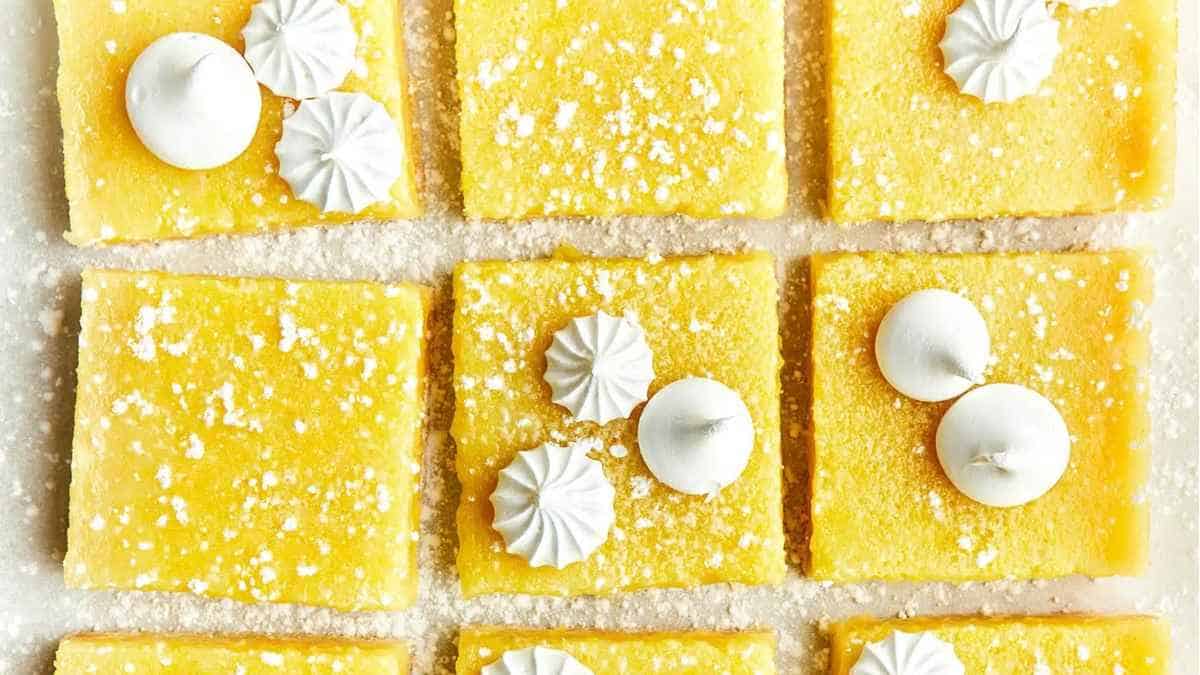 Lemon bars on a baking sheet with white icing.