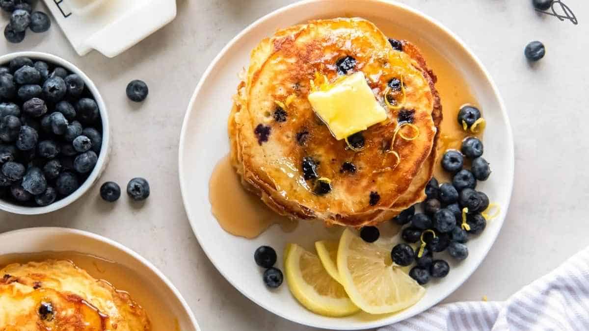 Pancakes with blueberries and lemons on a plate.