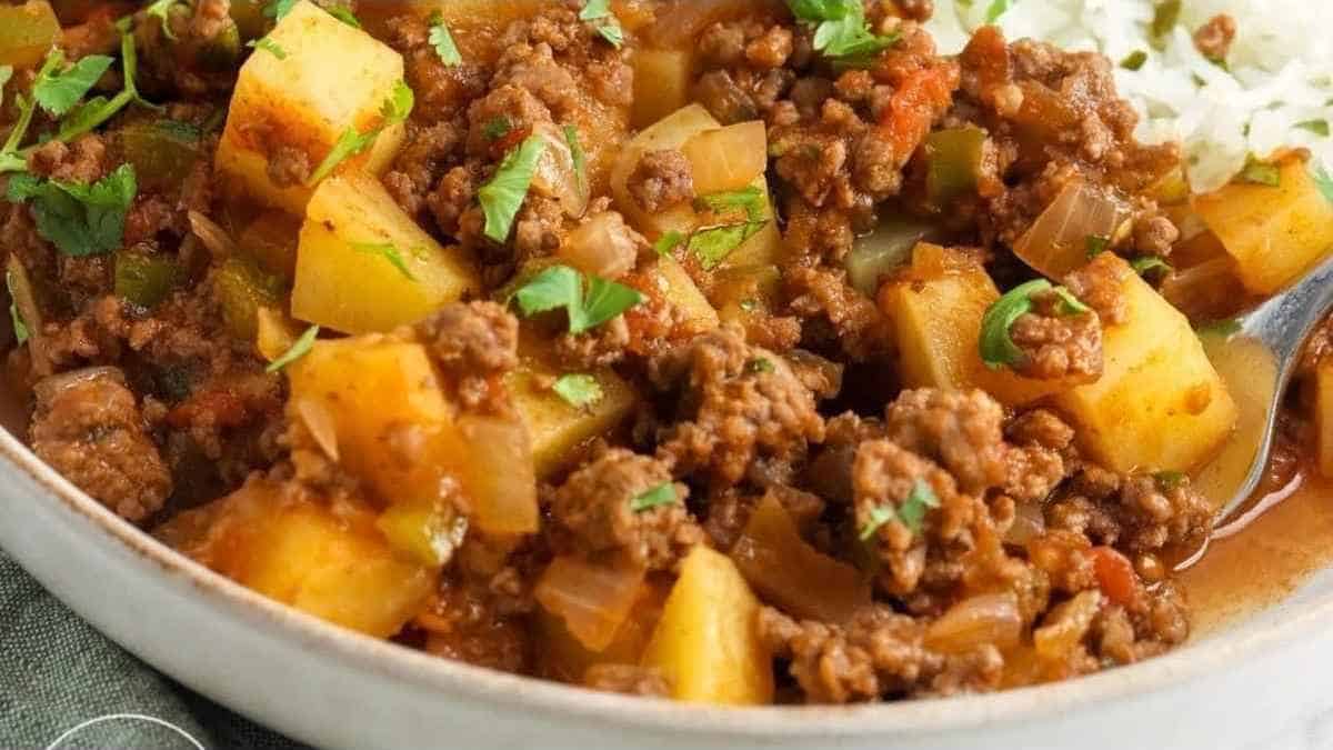 A bowl of beef and potato stew with rice.