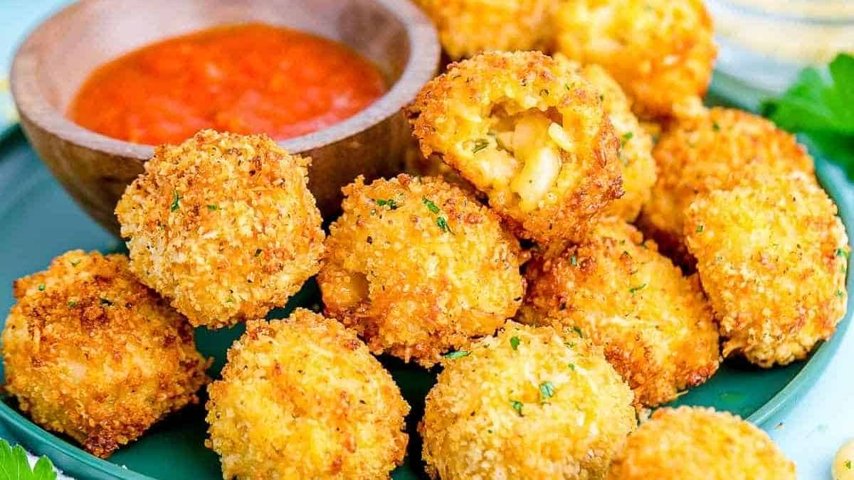 Fried cheese balls on a plate with dipping sauce.