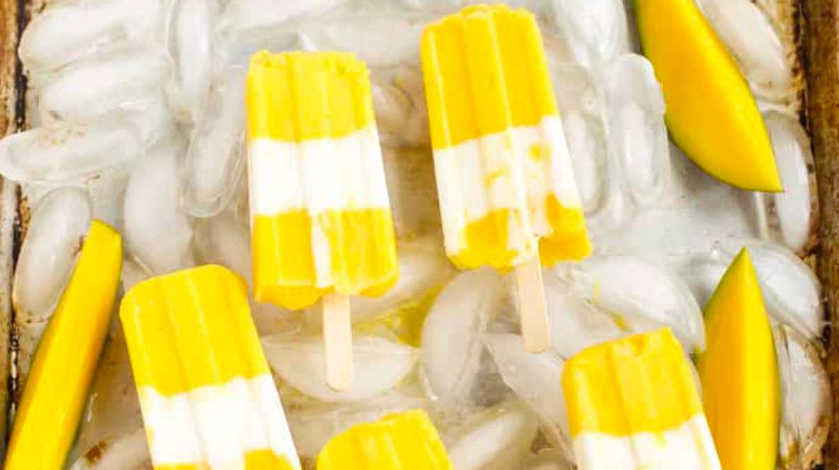 A tray of mango popsicles on ice.