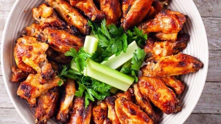 A plate of chicken wings and celery.