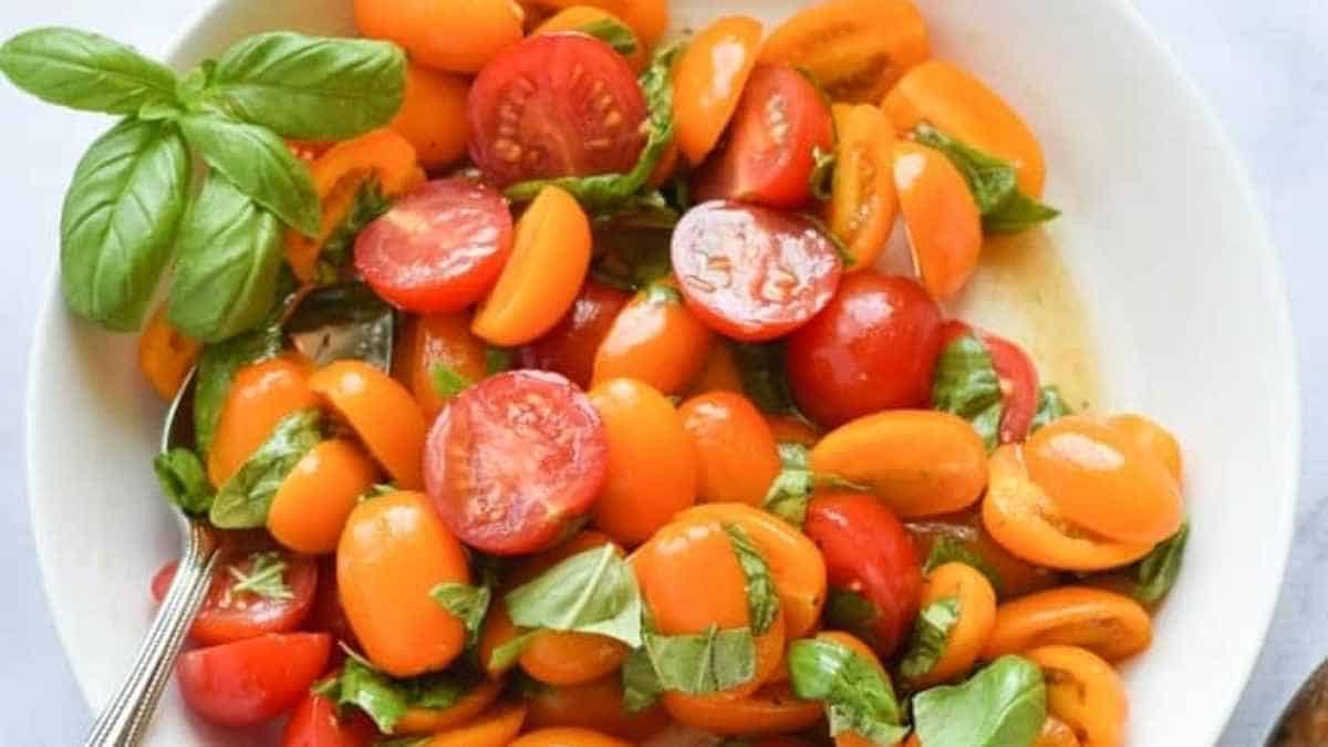 Tomatoes and basil in a white bowl.