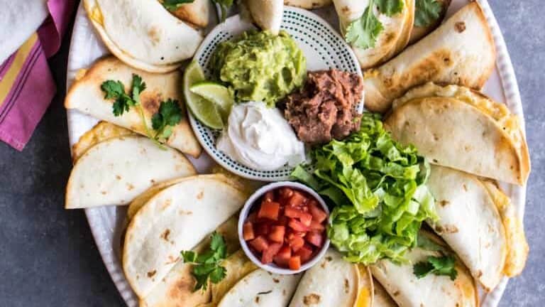 Quesadillas on a plate with guacamole and guacamole.
