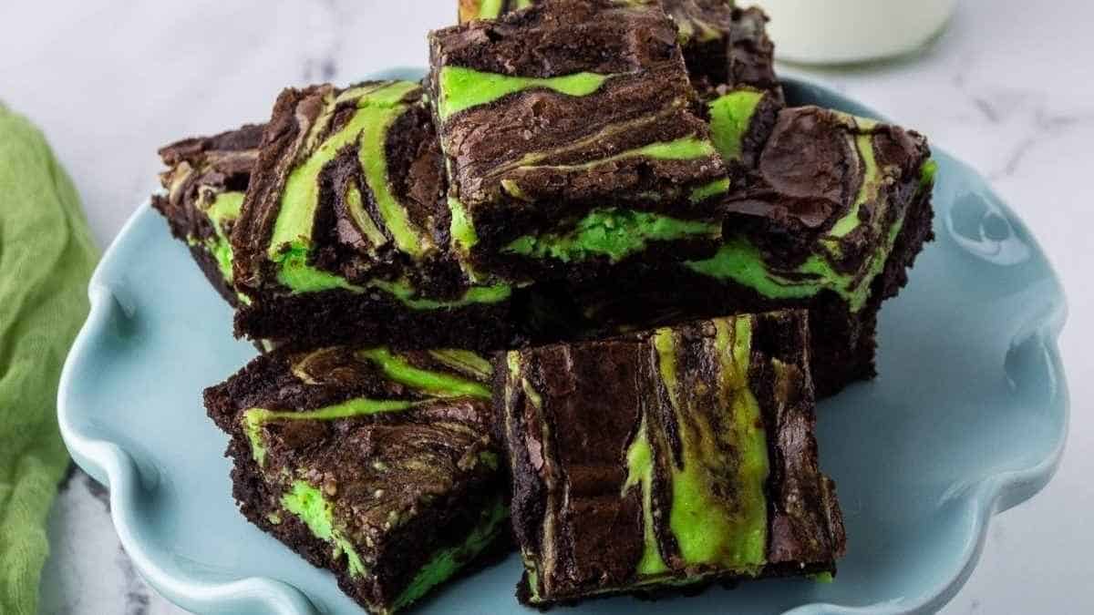 A plate of brownies with green frosting.