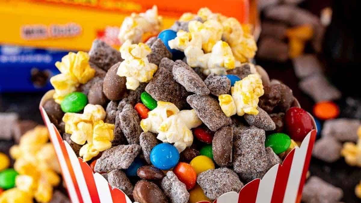 A bowl full of popcorn, candy, and m&m's.