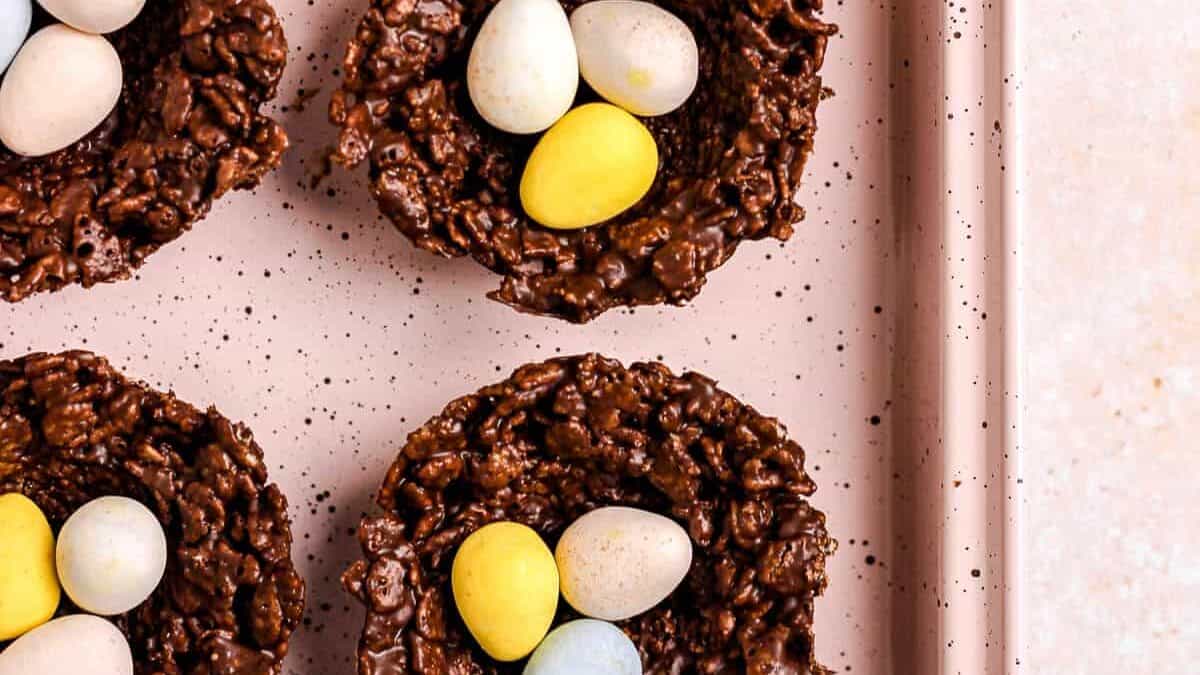 A tray of easter nests with chocolate eggs on top.