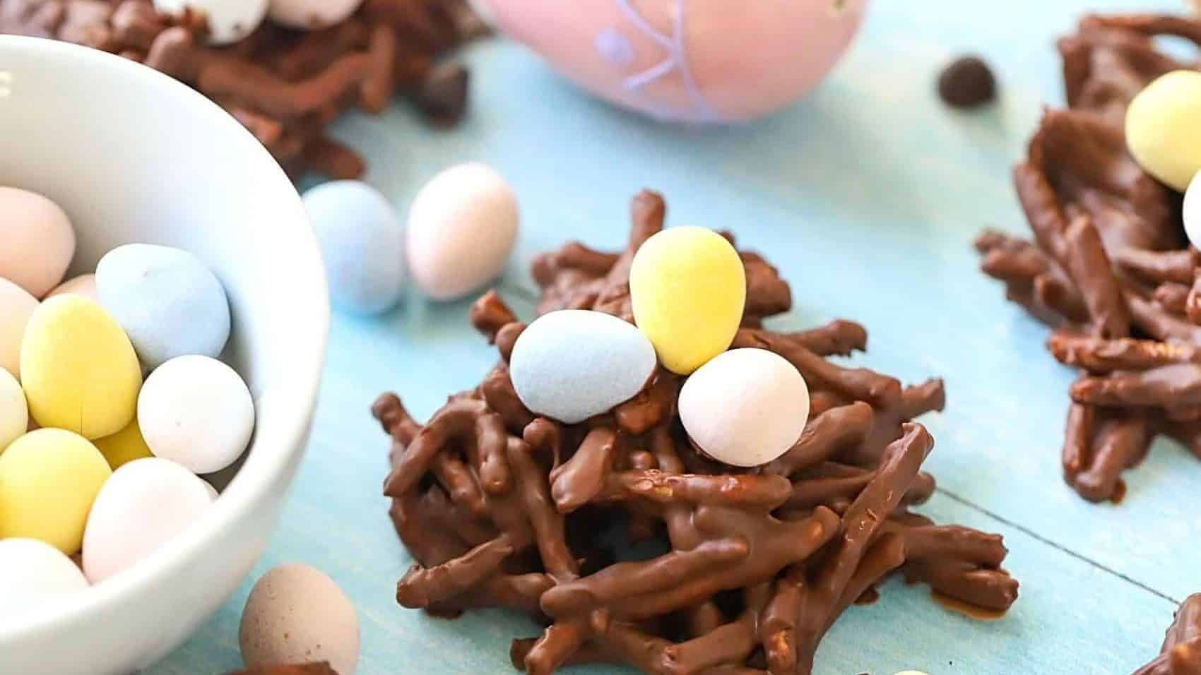 Chocolate easter nests on a table with easter eggs.