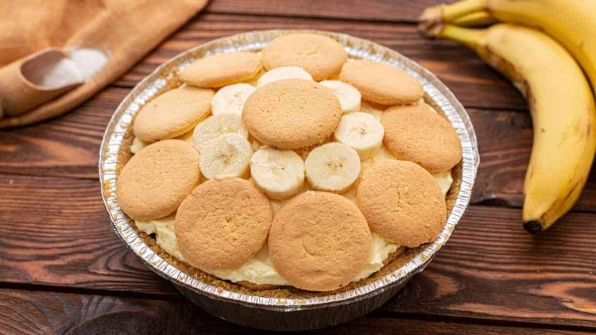 A banana pie in a tin on a wooden table.