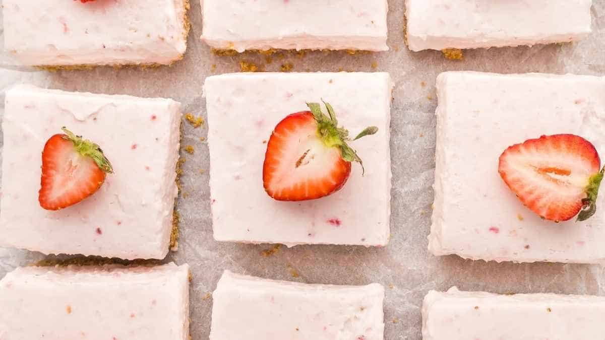 Strawberry cheesecake squares on a baking sheet.