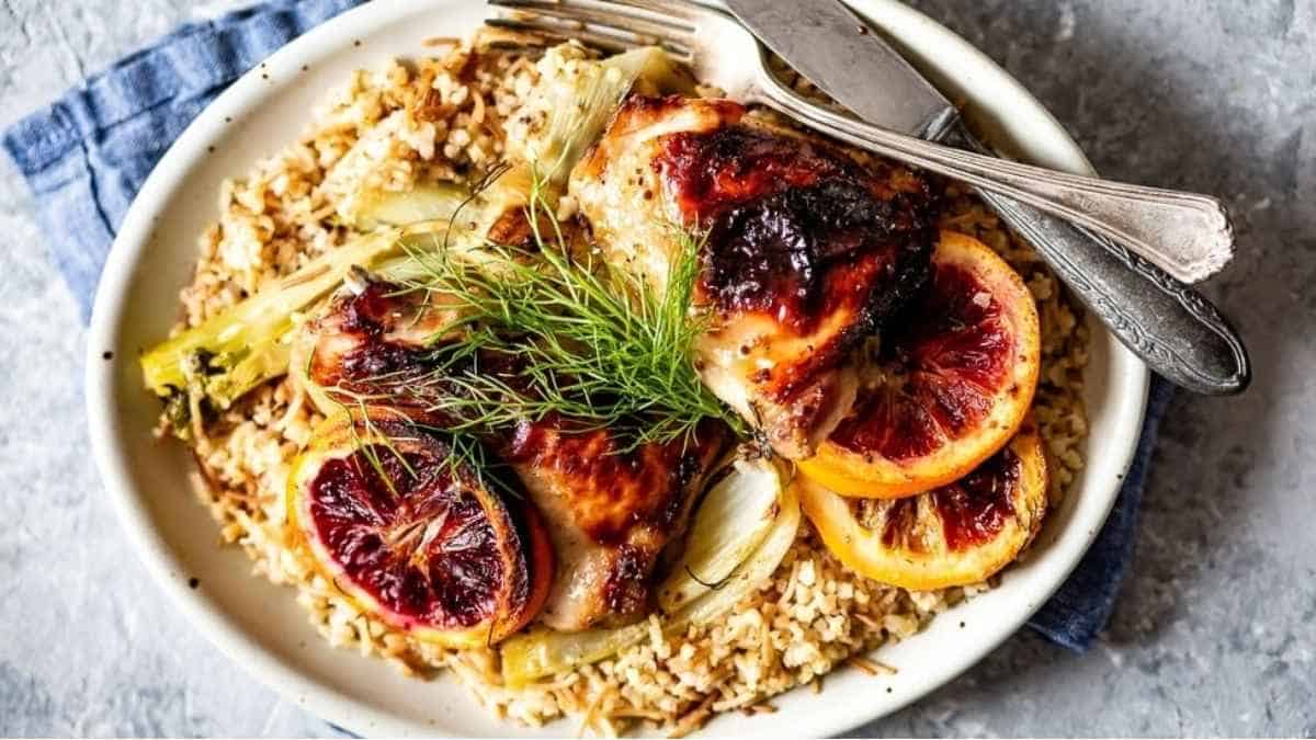 Blood orange chicken on a plate with rice and dill.