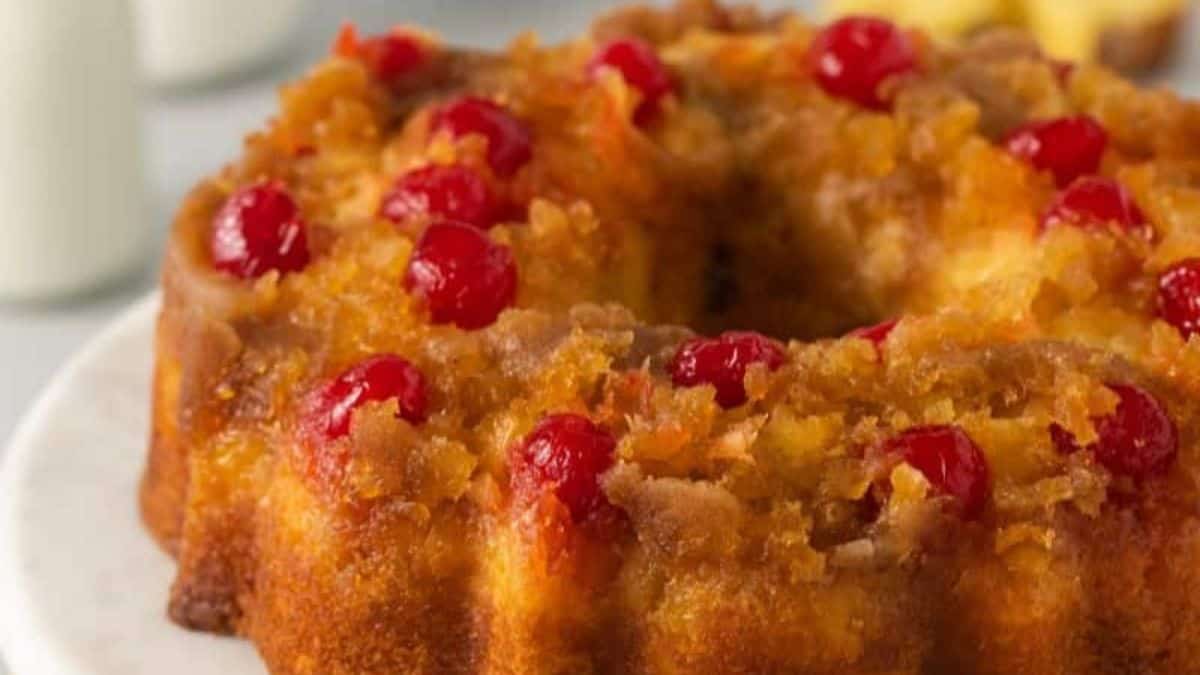 A pineapple upside down cake with cherries on top.