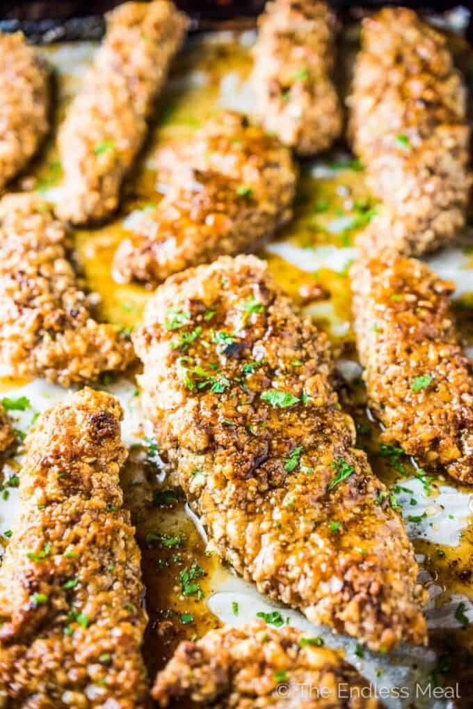Chicken tenders baked with herbs in a pan.