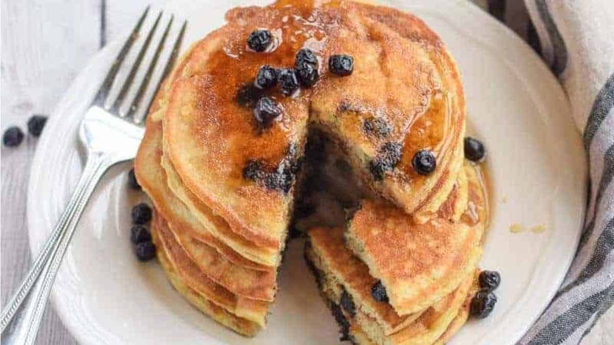 A stack of pancakes with blueberries on top.