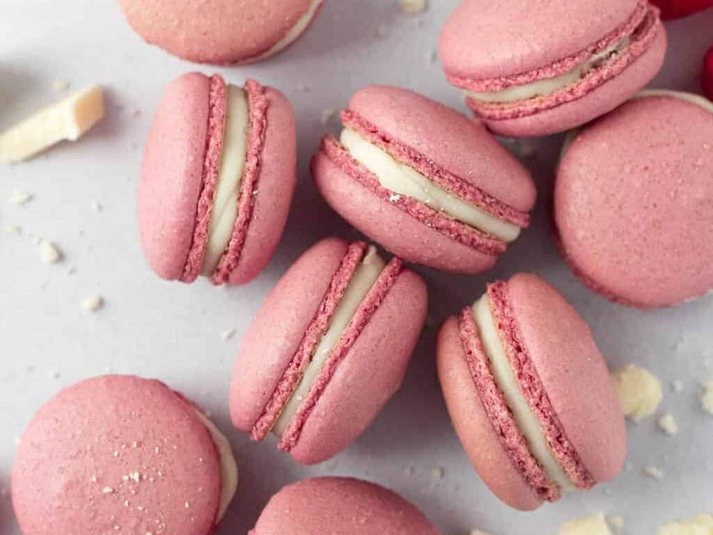 Pink macarons with white chocolate and raspberries.