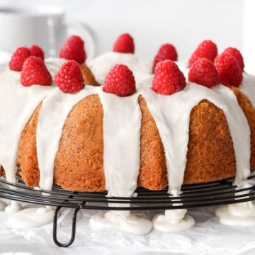 A bundt cake with icing and raspberries.