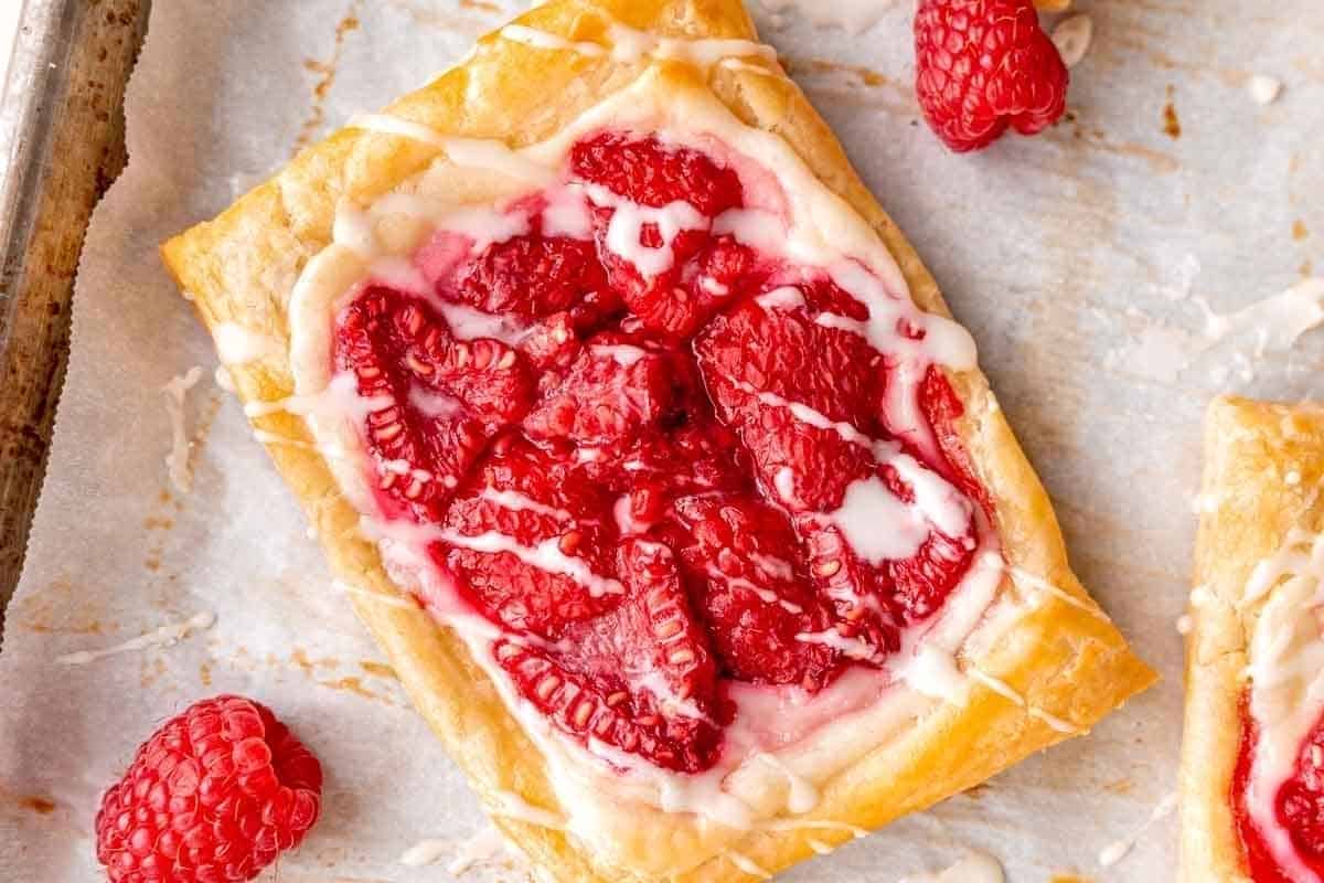 Raspberry tarts on a baking sheet.