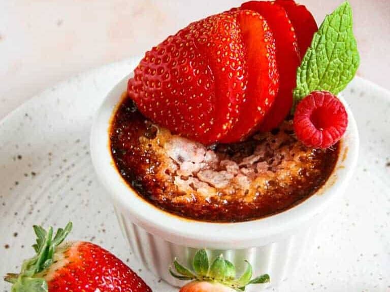 A dessert with strawberries and raspberries on a white plate.