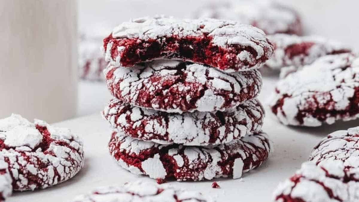 A stack of red velvet crinkle cookies with powdered sugar.