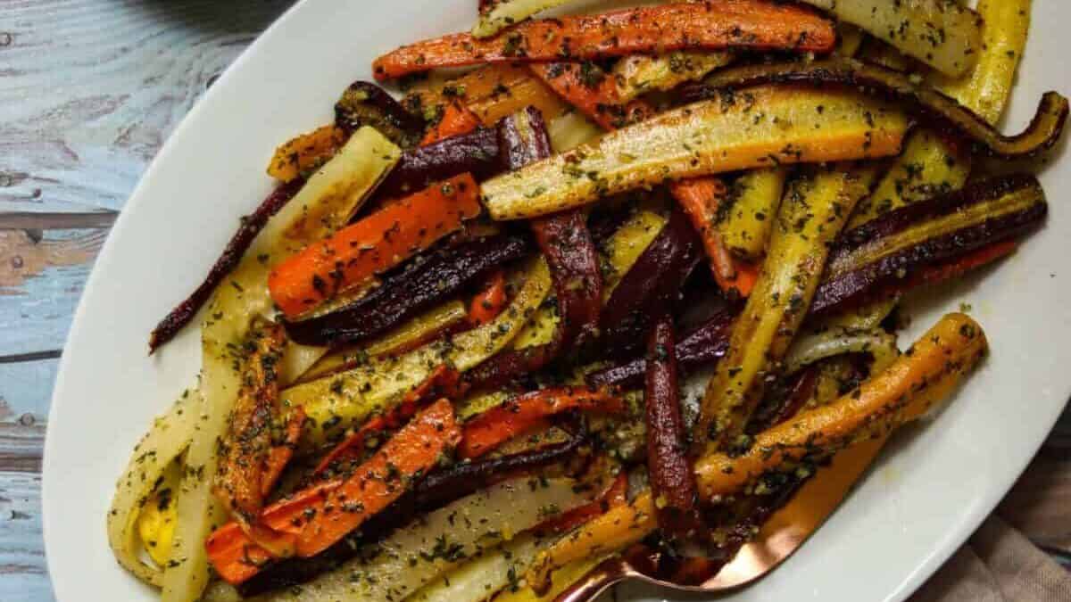 A plate of colorful carrots and a spoon.