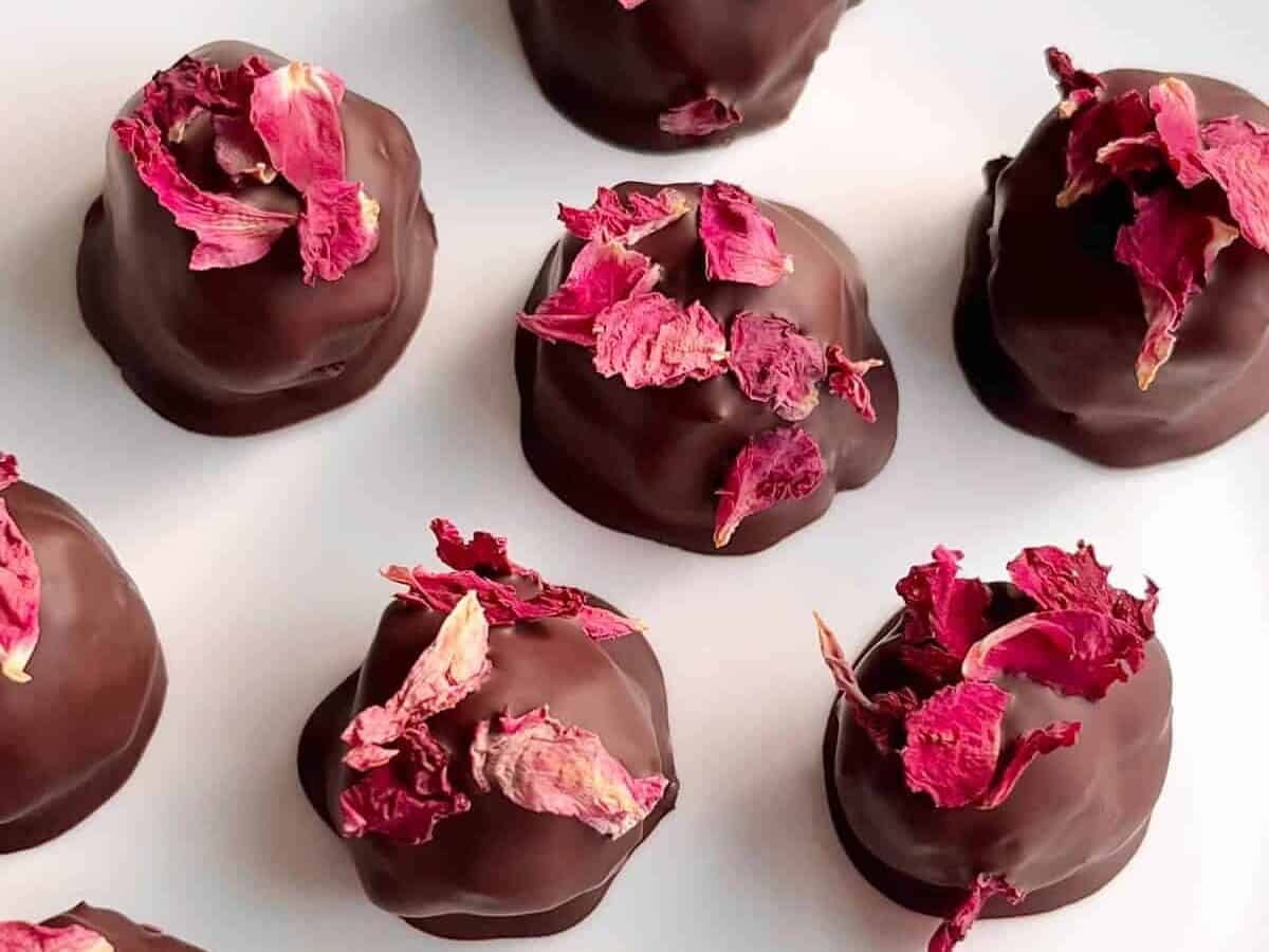 Chocolate covered roses on a white plate.