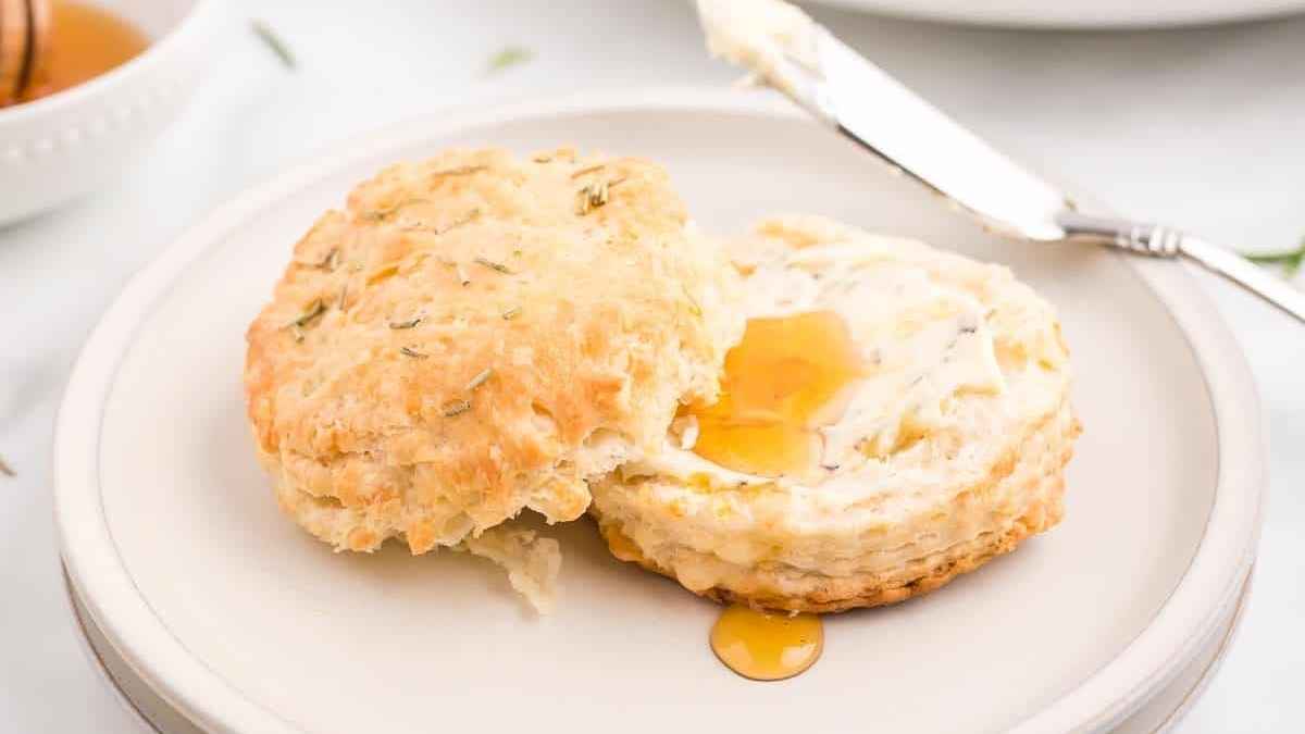 A biscuit with honey on a plate.