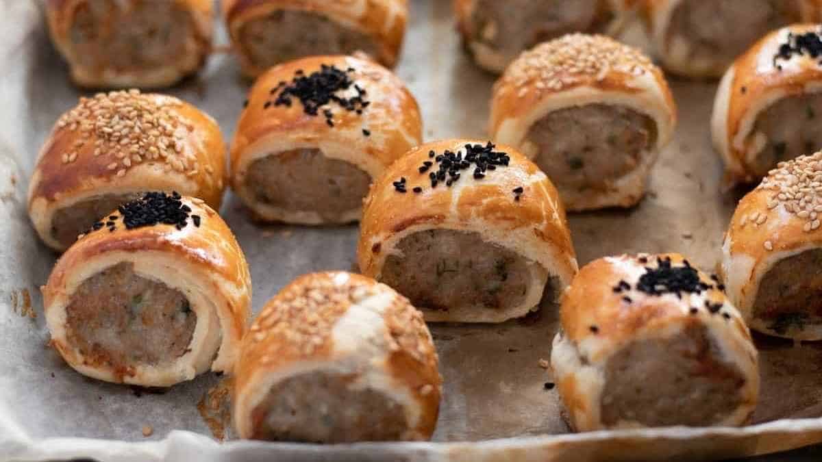 A tray of meat rolls with sesame seeds and sesame seeds.