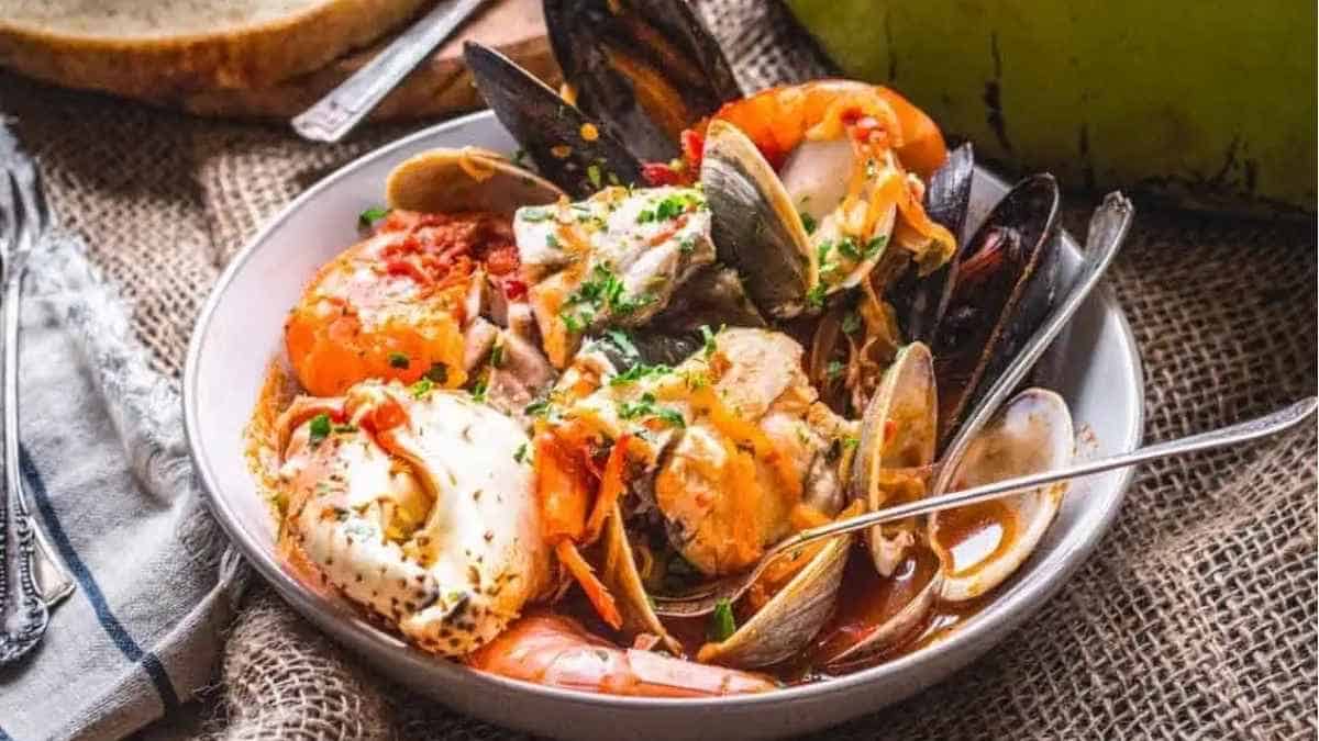 A bowl of seafood stew with clams and mussels.