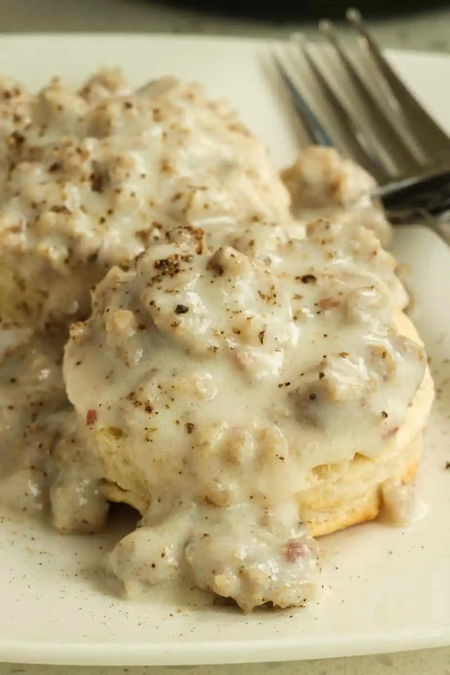 A delicious plate of biscuits and gravy made with ground sausage.