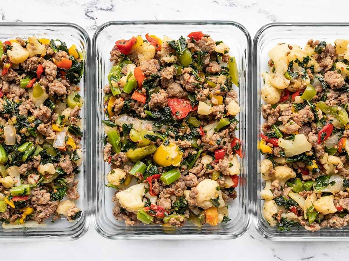 Three glass baking dishes with meat and vegetables in them.