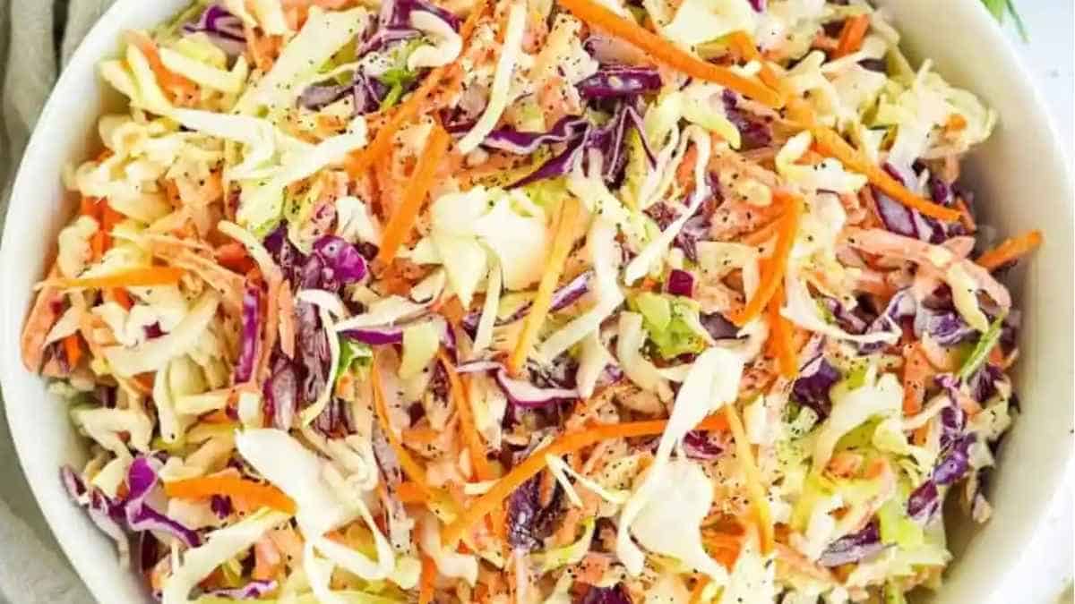 A bowl of coleslaw with carrots and celery.