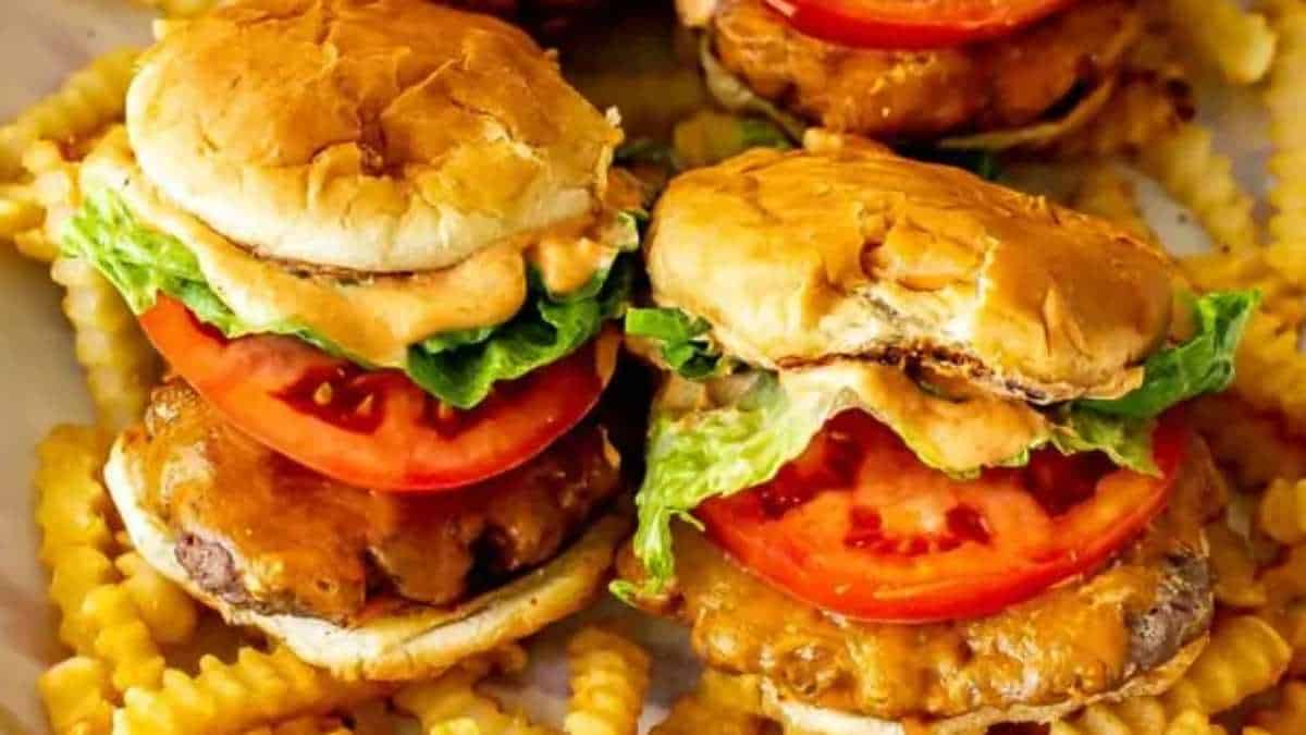 Burger sliders on a plate with french fries.