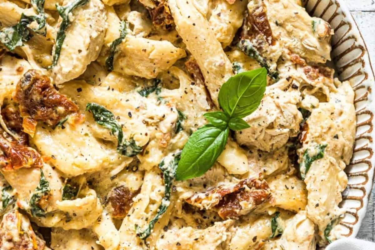 Chicken and spinach pasta in a white dish.