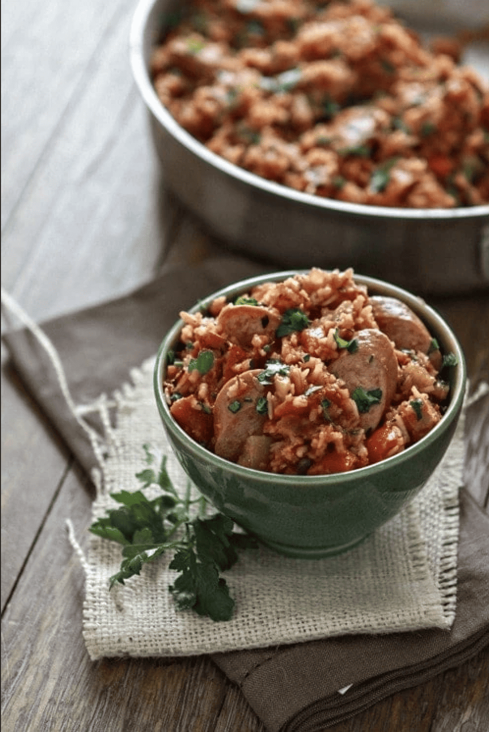         A bowl of rice and sausage on a table, perfect for those looking for sausage recipes.