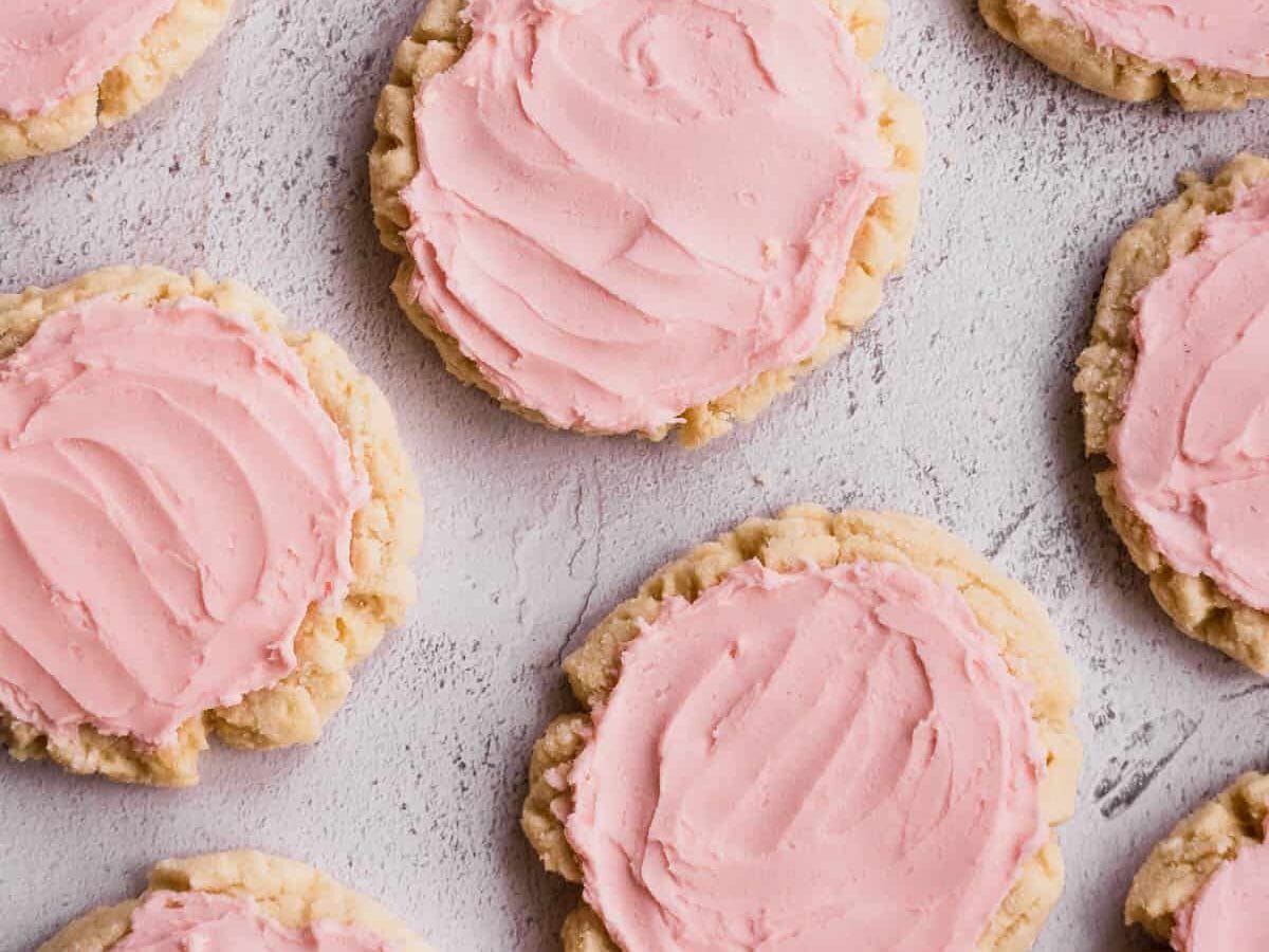Pink frosted cookies on a white surface.
