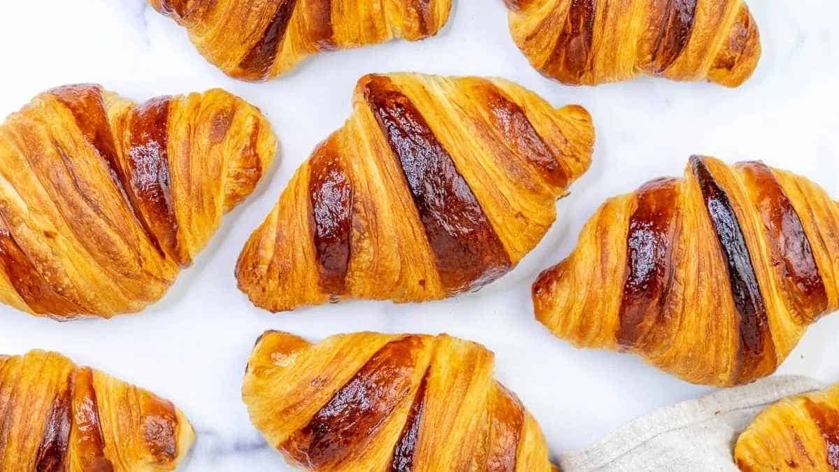 A group of croissants on a marble countertop.
