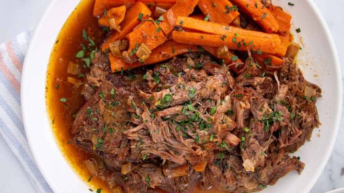 A plate of roast beef with carrots and gravy.