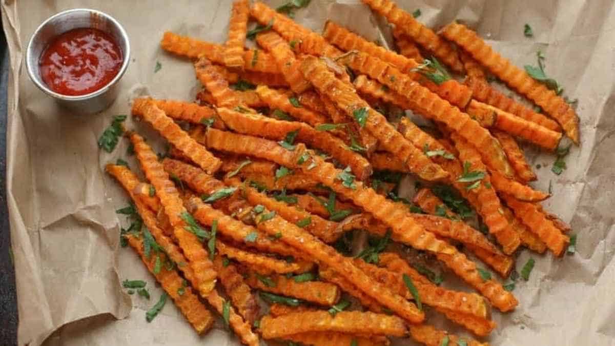 A plate of sweet potato fries with a dipping sauce.