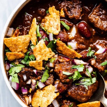 A hearty bowl of beef chili made with tender chuck steak, served with crispy tortilla chips.