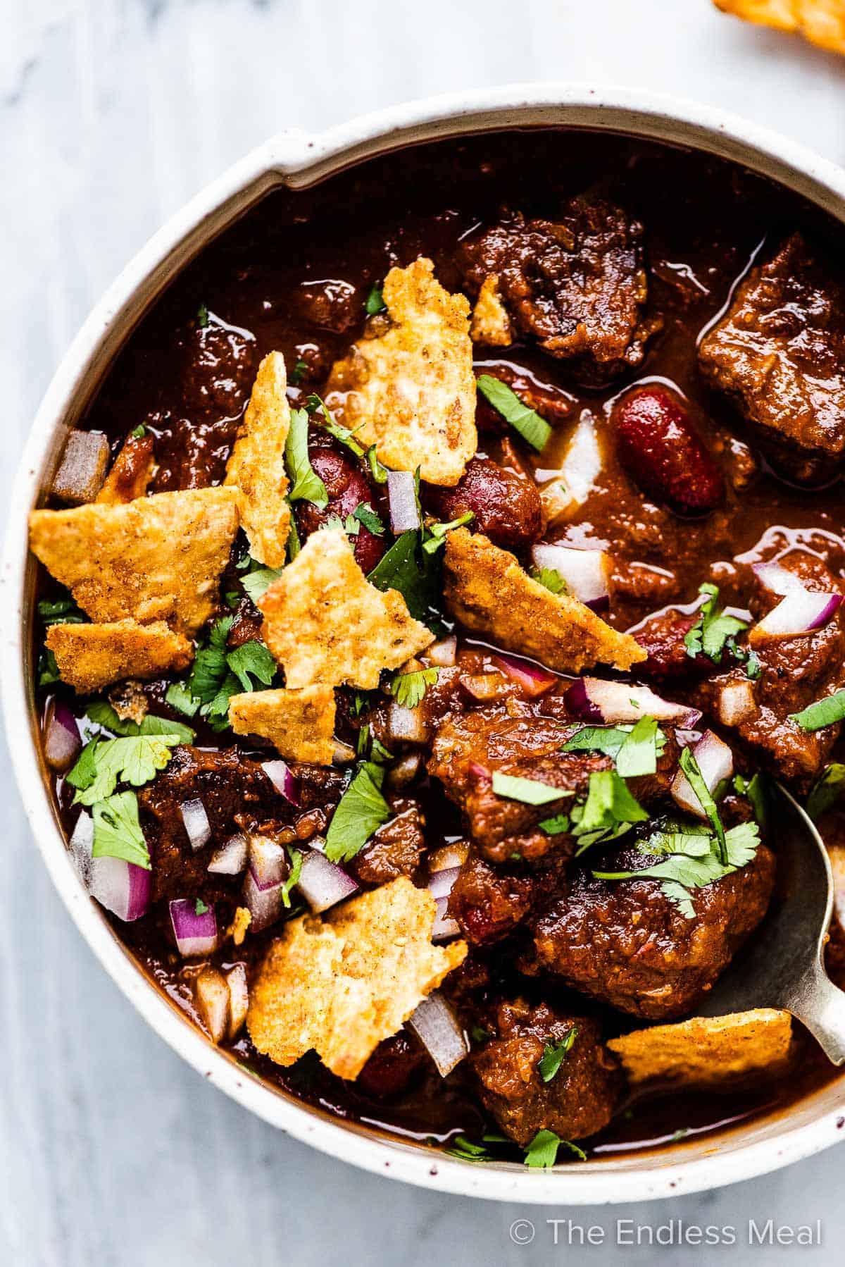 A hearty bowl of beef chili made with tender chuck steak, served with crispy tortilla chips.