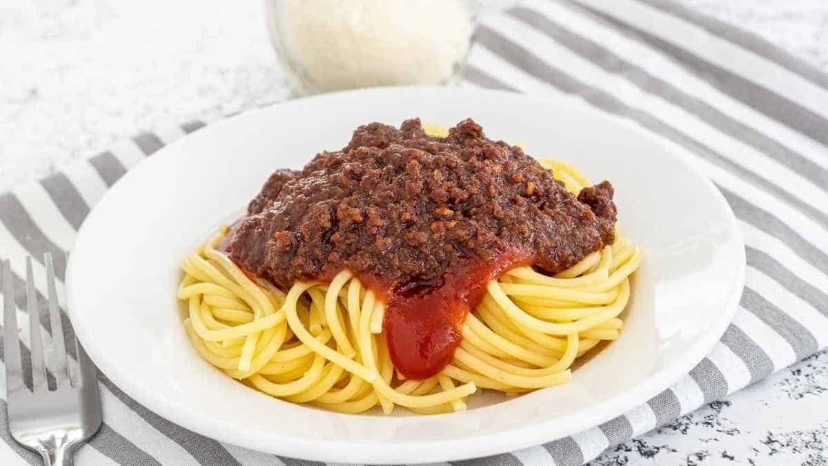 A plate of spaghetti with sauce.