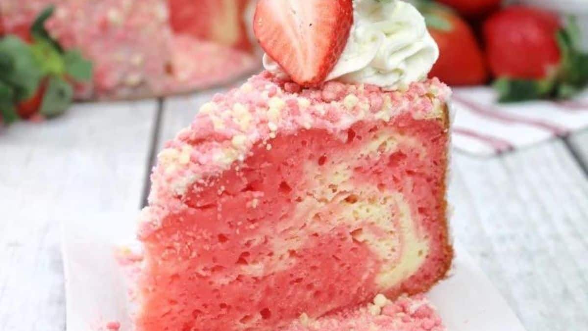 A slice of strawberry cake with whipped cream and strawberries.