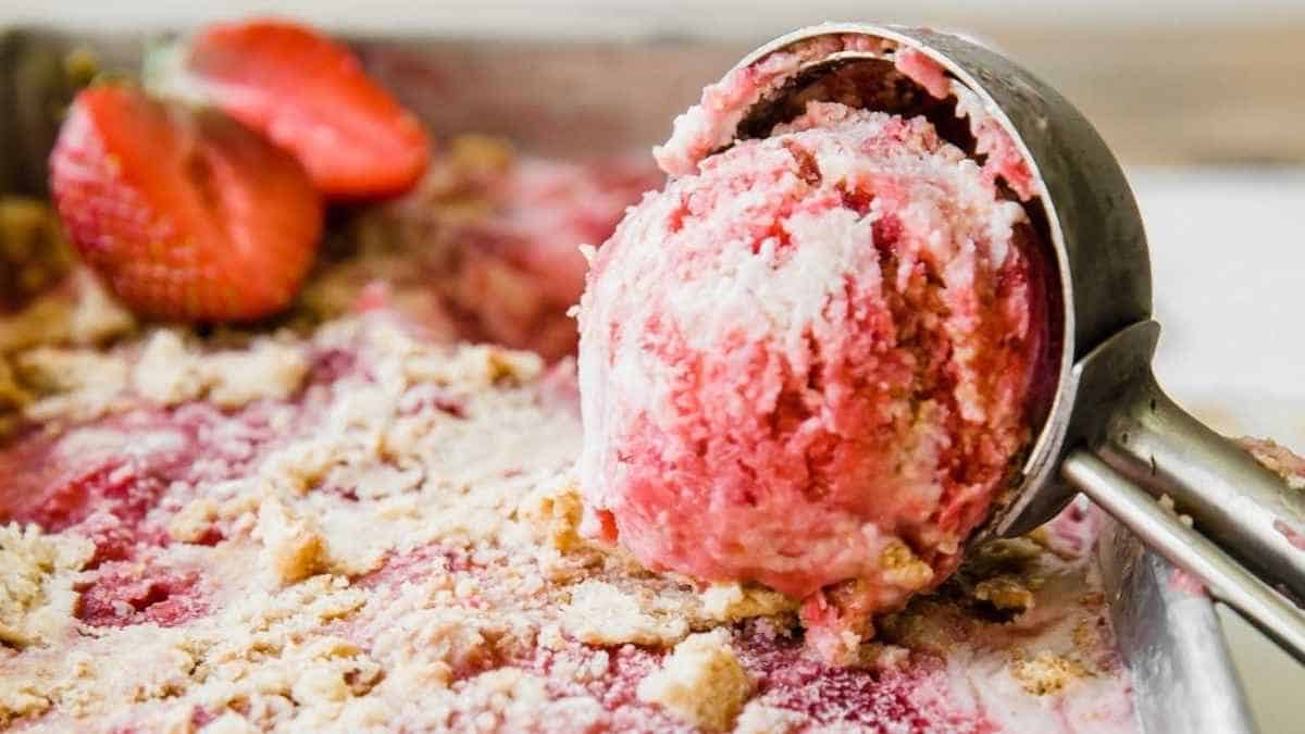 A scoop of strawberry ice cream in a pan.