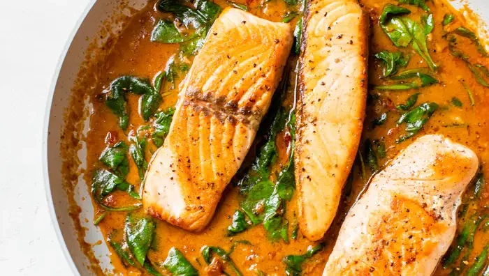 Salmon and spinach in a skillet.