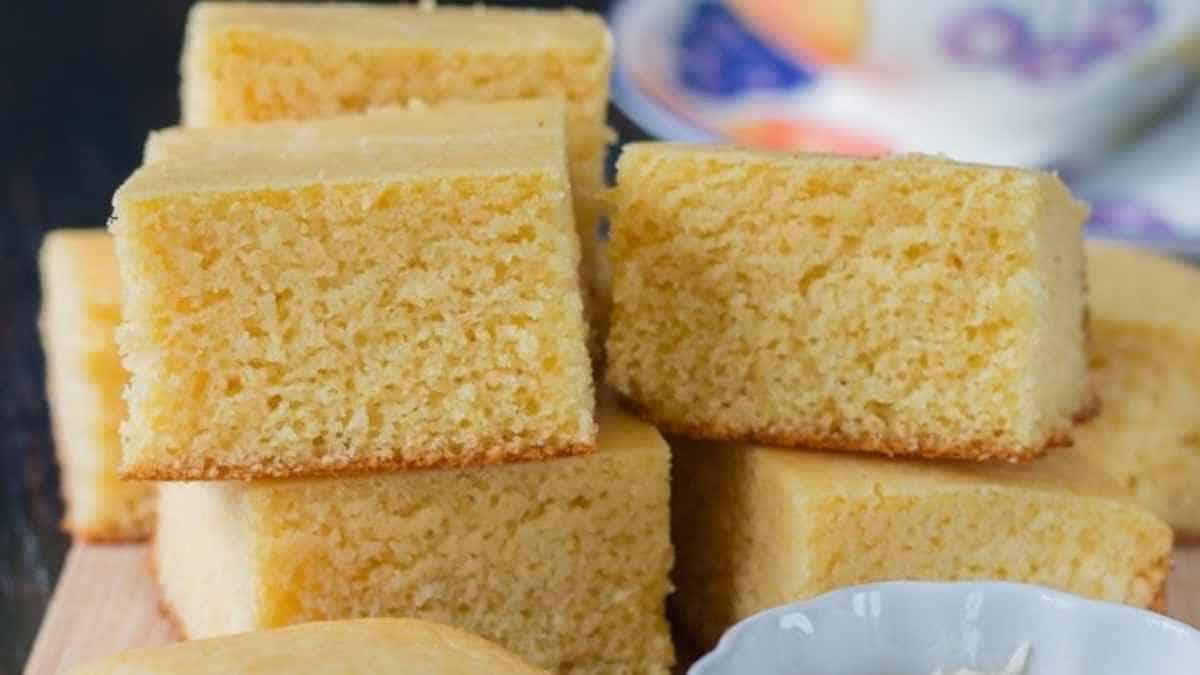 A stack of squares of cornbread on a cutting board.