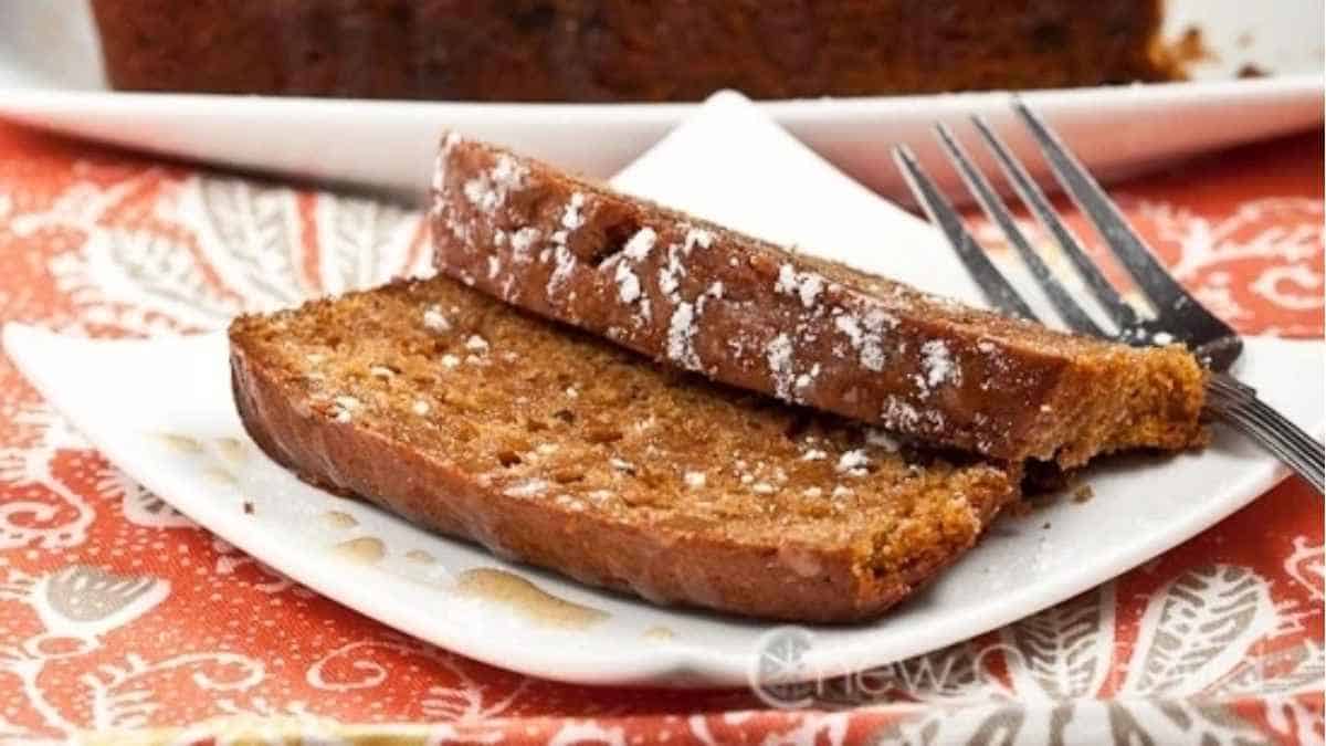 A slice of pumpkin bread on a plate with a fork.