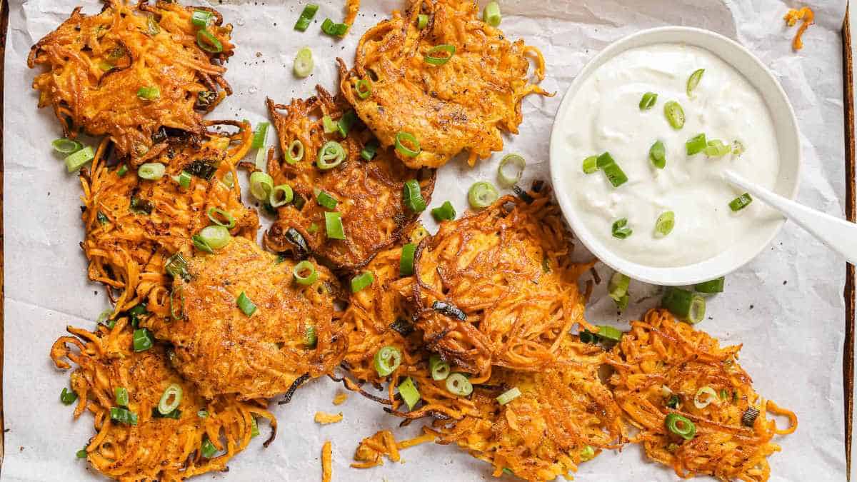 Sweet potato latkes with sour cream and green onions.
